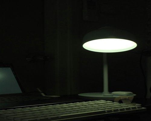 Lámpara de escritorio de luz cálida iluminando un teclado